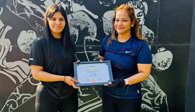 “Two women standing together, one holding a framed certificate of achievement.”