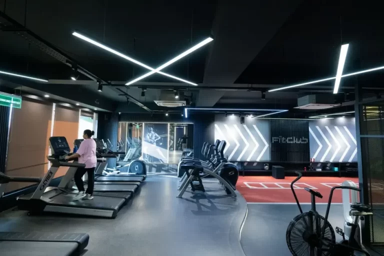 Person walking on treadmill in modern gym.