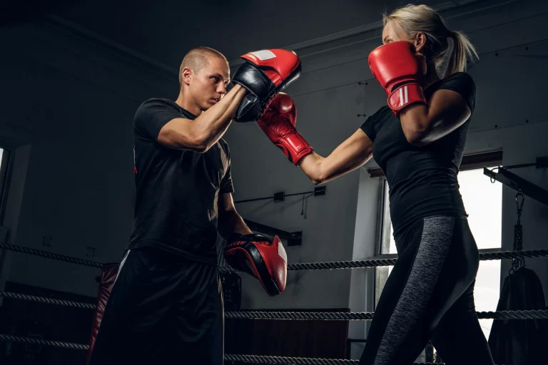 girl has a training at fitness centre with experienced boxer
